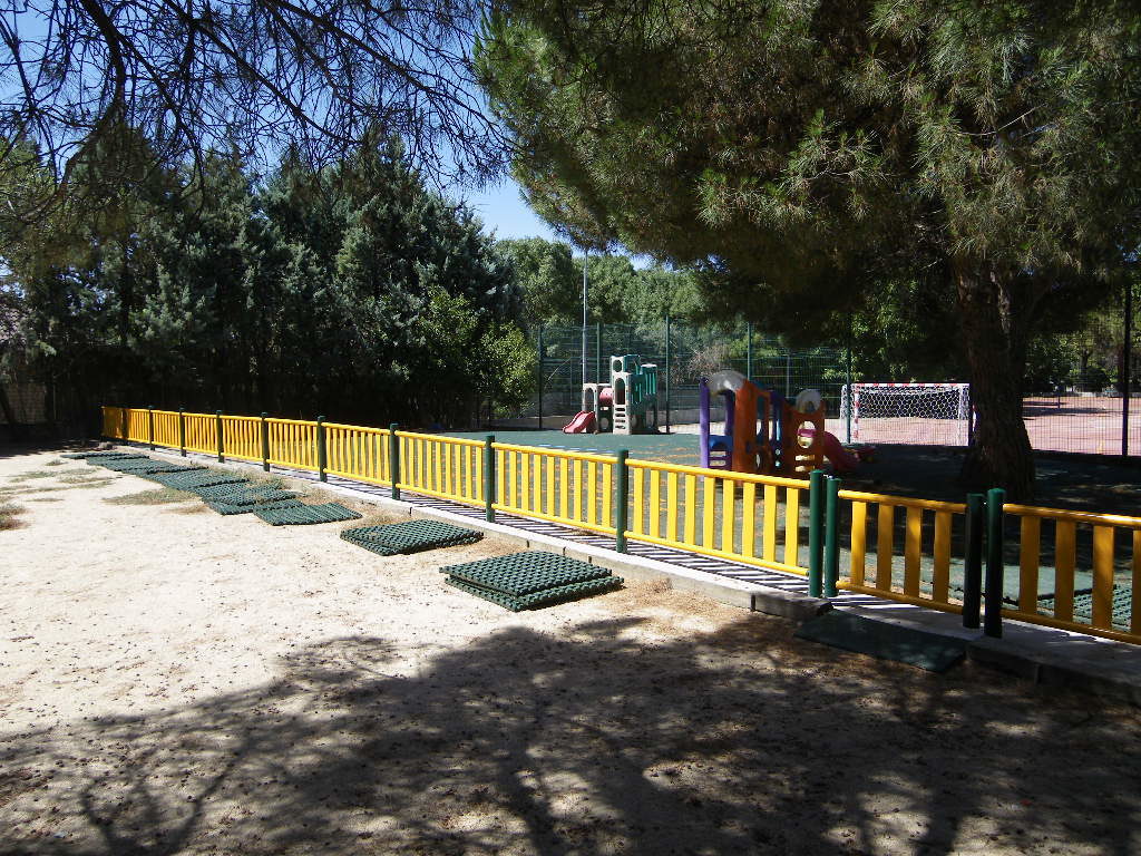 Valla metalica de colores y pavimento de caucho en losetas Parque Infantil Colegio Montesori. Alpedrete. Madrid.