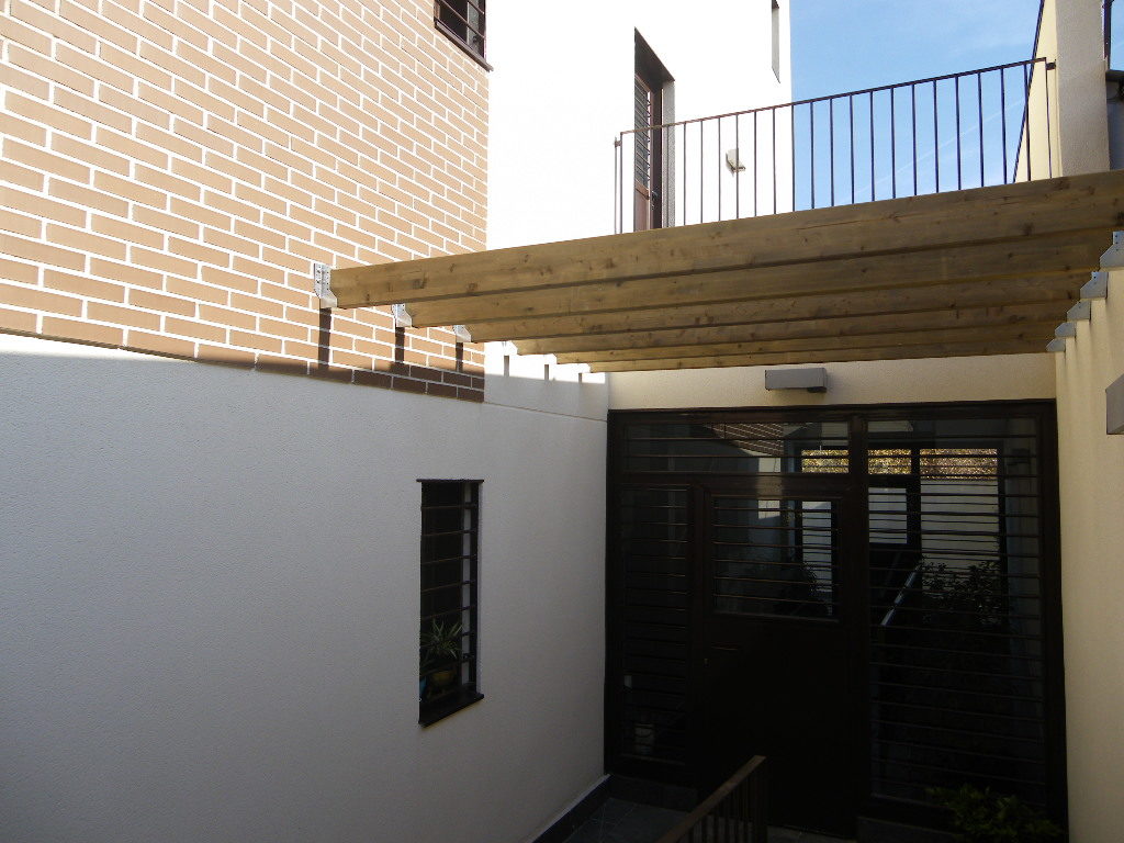 Pérgola de madera con medidas especiales y soporte a pared. Estudio de arquitectura Madrid.