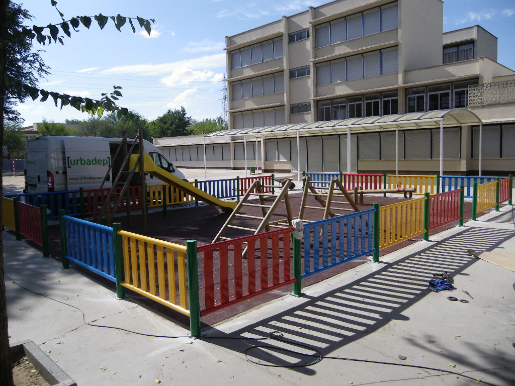 Valla metálica de colores Urbadep y pavimento de caucho en losetas parque infantil Colegio Santa María. Madrid.